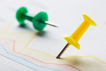 Marking financial chart by pins.Share listing and checking financial chart. Concept of banking, financial report and financial audit.