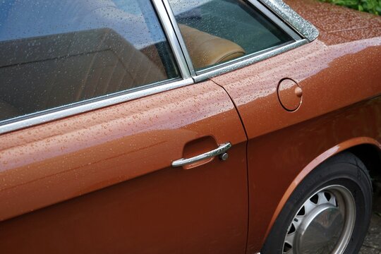 Eleganz und Linienf&uuml;hrung im Detail einer Limousine mit Wankelmotor der Sechzigerjahre und Siebzigerjahre in Braun Metallic mit Regentropfen in Wettenberg Krofdorf-Gleiberg bei Gie&szlig;en in Hessen