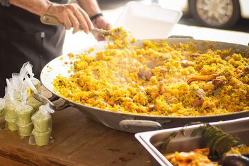 Latin woman prepares a paella in her small business