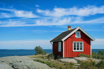 Red wooden house or cottage near the sea in Sweden on a sunny summer day