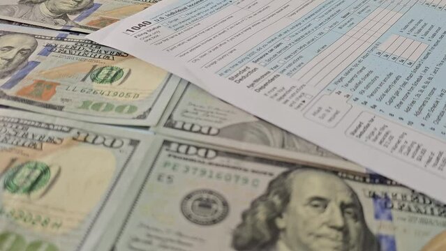 Dollar bills is on tax form 1040 U.S. Individual Income Tax Return. Time to pay taxes