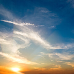 Blue sky with cirrus clouds and sunrise.