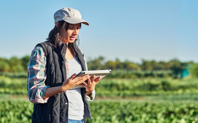 Woman, farmer and tablet in countryside for research, crops or plants information on agriculture. Nature, tech and farm owner with digital for garden inspection, ecology or weather check in Australia © peopleimages.com