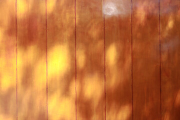 Light and shadow on the golden-yellow wooden wall.