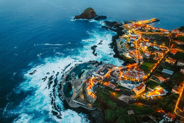 Aerial view of Porto Moniz with volcanic lava swimming pools, night city,  Madeira, Portugal