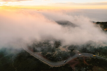 Aerial view of majestic mountain ridges at sunrise with falling fog from top of Pico do Areeiro,...
