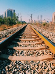 Vertical shot of railroad tracks with buildings in the background
