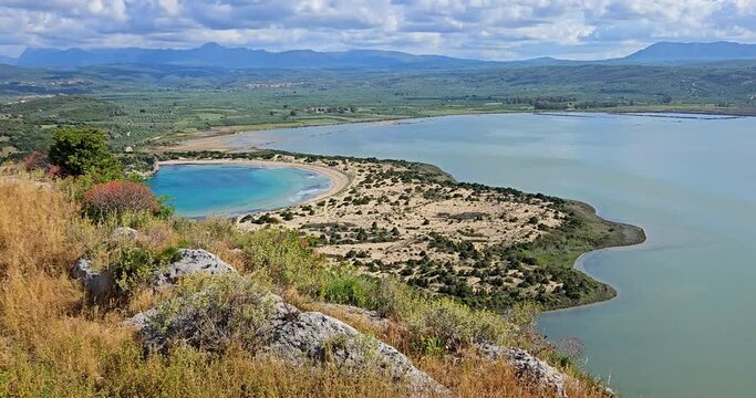 Voidokilia beach and Gialova Lagoon landscape with colorful flowers and green vegetation, view from the Old Navarino Fortress (Palaiokastro), Greece