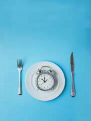 Naklejka premium Top view alarm clock on white plate with knife and fork on blue background. Intermittent fasting, Ketogenic dieting, weight loss, meal plan and healthy food concept
