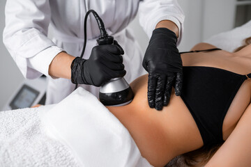 Following ultrasound cavitation of the abdomen of woman, the vacuum procedure is implemented to enhance results. 