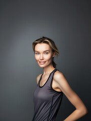 Fototapeta premium Young slim athletic blonde woman on a gray background. Active lifestyle, weight loss, motivation.
