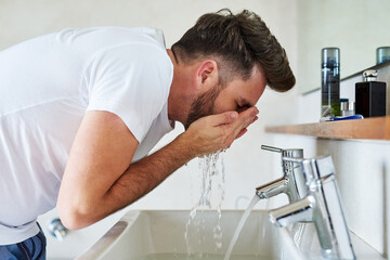 Man, washing face and home bathroom with water splash, body care or skincare morning grooming...