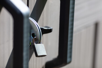 Closeup of Secured Padlock on Industrial Gate During Bright Day, Emphasizing Security and...
