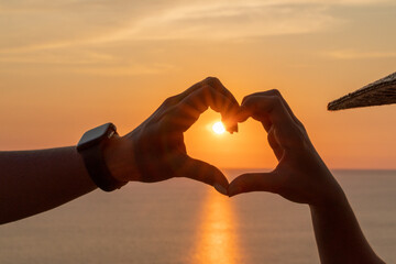 Hands heart sea sanset. Hands forming a heart shape made against the sun sky of a sunrise or sunset...