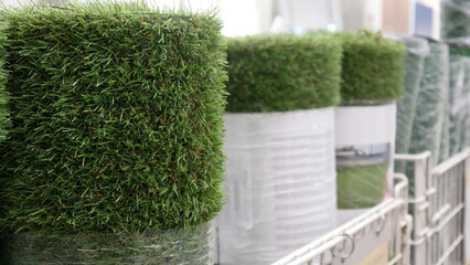 Close-up of many artificial turf rolls standing in a row on the market