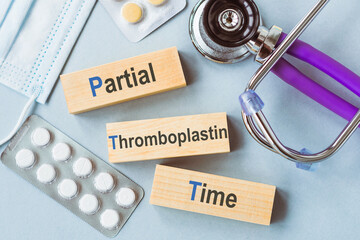 Partial Thromboplastin Time Medical Concept Depicted With Wooden Blocks on a Laboratory Desk