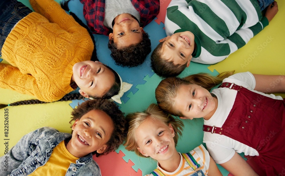 Poster happy, kids and laying in circle on mat in school with top view for relax, fun and portrait in class