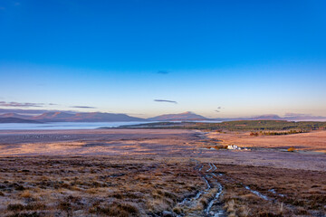 Lonely isolated house in the middle of nowhere by the hills in a crisp cold winter morning at sunrise at the Scottish Highlands