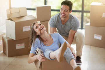 Happy, couple and moving with boxes in new home for real estate, playing or together for growth....