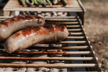 Closeup of sausages on eco grill. Outdoor picnic. .copy space