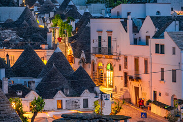 Trulli of Alberobello, Puglia, Italy. town of Alberobello with trulli houses among green plants and...