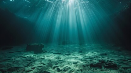  The sun illuminates the sandy ocean floor via the transparent water, featuring a rock in the near foreground and a rock outcropping up ahead
