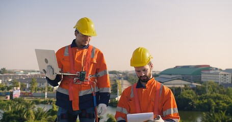 Two engineers solar technicians in reflective gear discussing working examine solar installations...