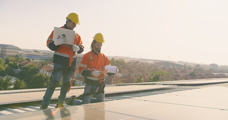 Two engineers solar technicians in reflective gear discussing working examine solar installations...