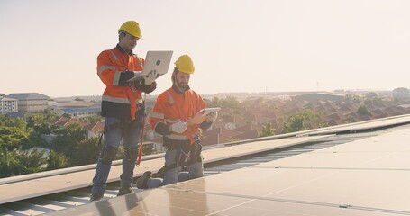 Two engineers solar technicians in reflective gear discussing working examine solar installations...