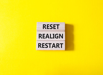 Reset Realign Restart symbol. Concept words Reset Realign Restart on wooden blocks. Beautiful yellow background. Business and Reset Realign Restart concept. Copy space.