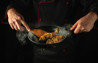 Preparing fried fish in a restaurant kitchen. Cook or fry rudd fish in a frying pan. Delicious fish dish idea