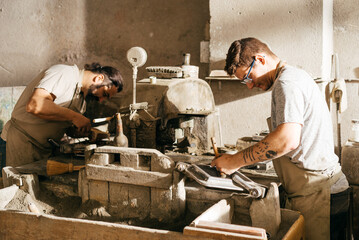 Men Working on Hydraulic Press Bench Making Cement Tiles in Industrial Workshop During Daytime
