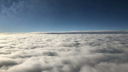 Naklejka premium Flying over clouds passenger airplane window