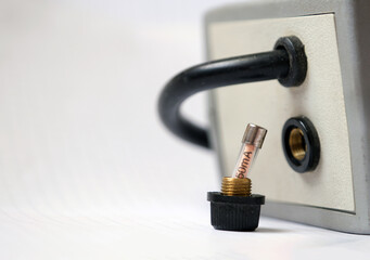 The removed power glass fuse from the glass fuse holder on an electrical appliance.