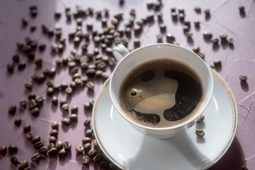 cup of coffee and coffee beans on pink background