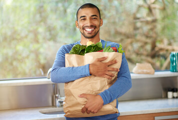 Man, excited and groceries in kitchen with vegetables, shopping and healthy food at home. Portrait...