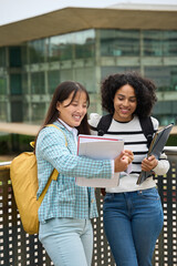 Two multiethnic students sharing notes outside the University