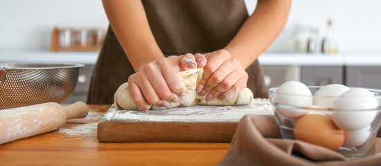 Woman kneading flour in kitchen