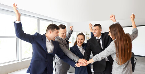 Business people putting hands together after negotiations in conference hall