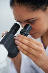 Woman, scientist and microscope for research, exam or analysis in laboratory experiment. Science,...
