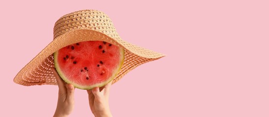Female hands holding watermelon in hat on pink background with space for text