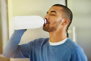 Man, container and milk drinking in home for morning beverage or calcium benefits, digestion or gut...