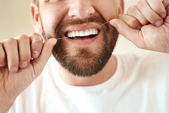 Man, dental and floss in morning for teeth cleaning in bathroom with wellness, healthy and oral hygiene. Routine, happy and fresh breath for grooming or care on weekend with closeup in Switzerland.
