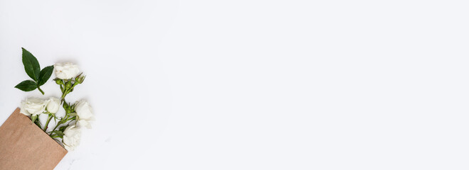 White garden roses in craft paper bag, floral greeting card, long banner