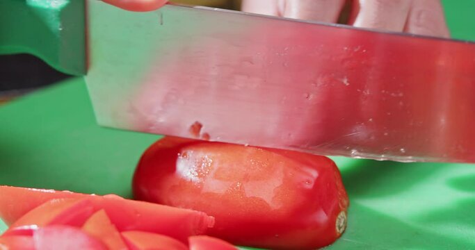 Cutting tomato with a professional knife.