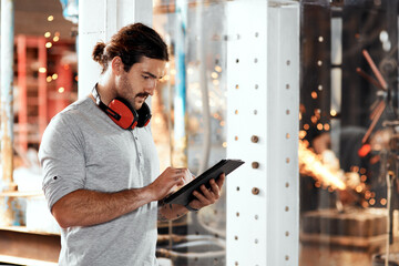 Tablet, manufacturing and man in factory for blacksmith planning or blue collar trade in small business. Startup, research and metal worker in workshop on technology for production or steel industry