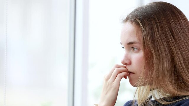 nervous and impatient young girl or woman biting nails