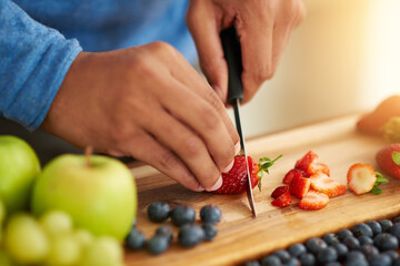 Fruits, hands and healthy food in kitchen for breakfast salad with knife and cutting board. Person...