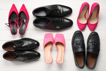 Male and female shoes on white wooden background. Top view