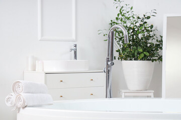 Clean towels on bathtub in light room, closeup